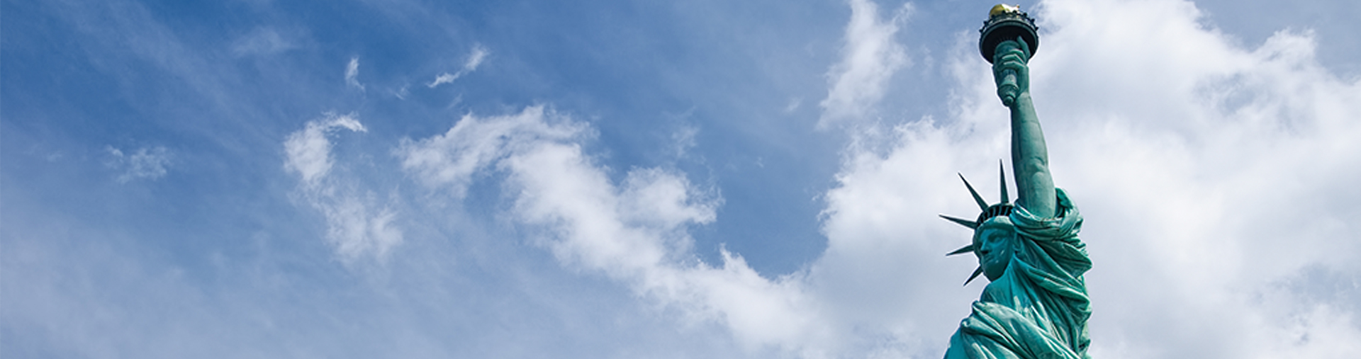 Statue of Liberty against a blue sky with clouds. Liberty Island, New York City.