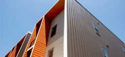 Low angle shot of the corner of an orange and tan building. (source: Getty Images)