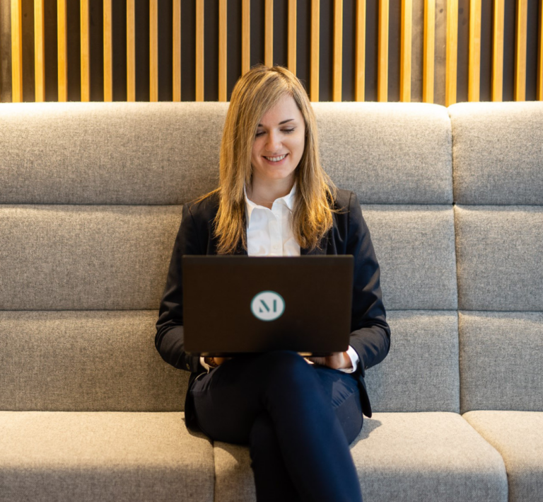A staff professional works on their laptop in the lobby of the firm’s Düsseldorf office. (credit: McDermott Will & Schulte)