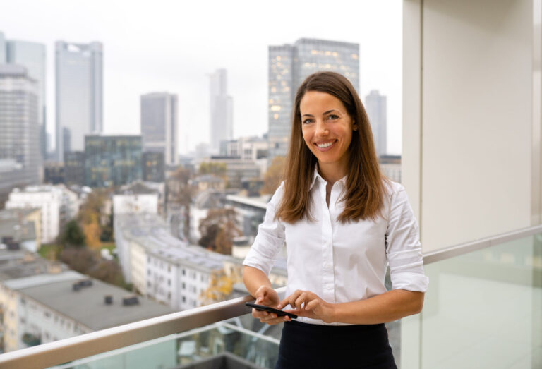 An employee smiles for the camera while taking in the view from one of the firm’s Germany offices. (credit: McDermott Will & Schulte)