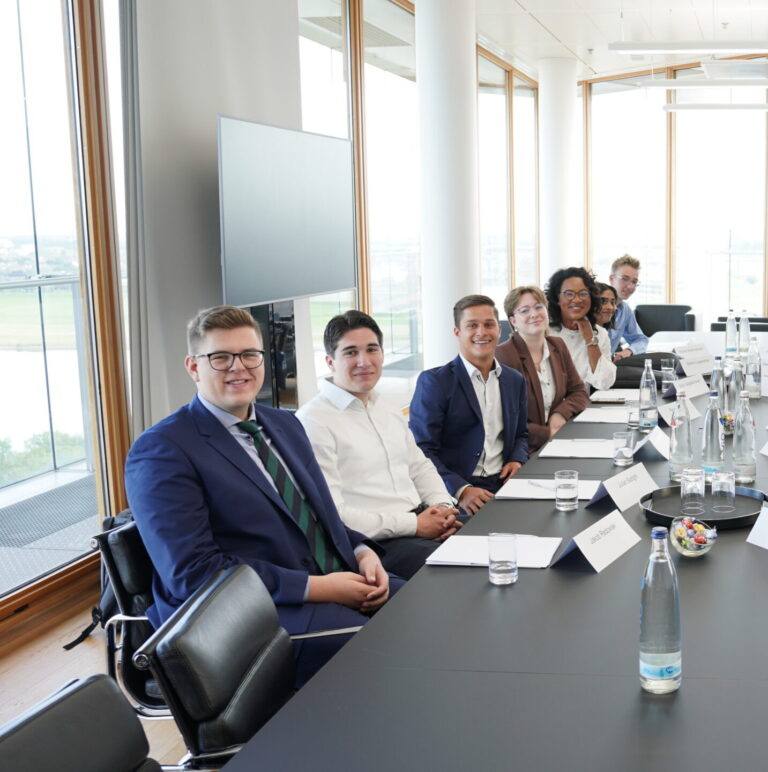Employees smile for a photo in a conference room at one of the firm’s Germany offices. (credit: McDermott Will & Schulte)